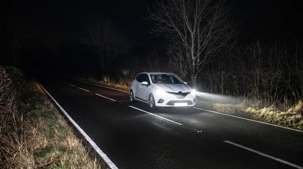 Strada di campagna completamente buia e senza altri veicoli: la Clio procede con gli abbaglianti accesi.