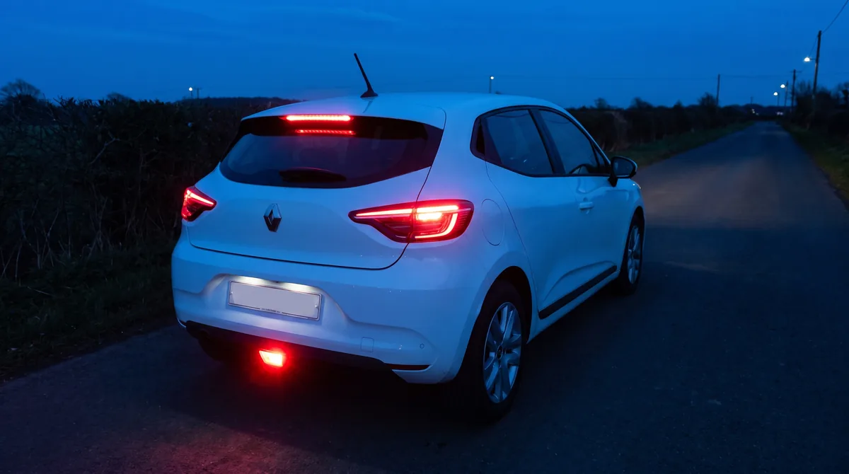 Parte posteriore della Clio al crepuscolo: luci di posizione, stop, terzo stop e retronebbia acceso in basso.